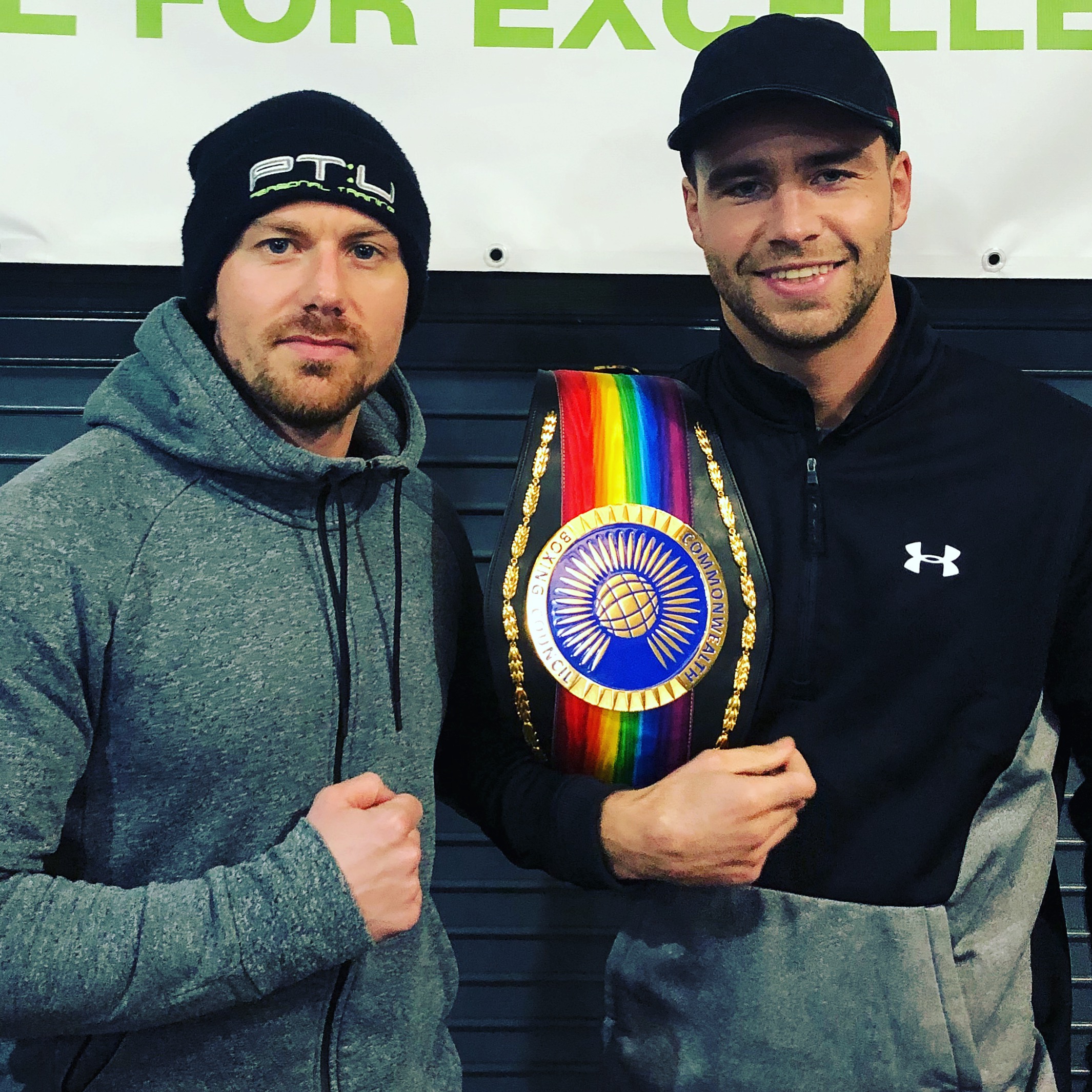 Rich & Felix Richard Jones Personal Trainer standing with successful martial arts client who has a championship belt draped over his shoulder